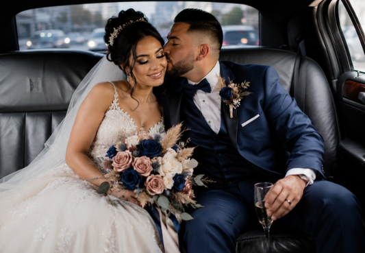 Bride and groom in a car with a bouquet of navy and blush roses