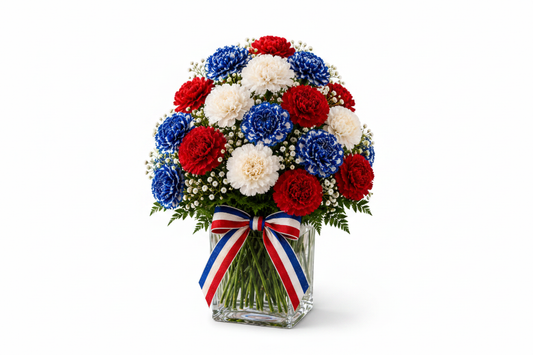 Star-Spangled Blooms patriotic red white and blue carnation arrangement in clear glass vase with striped ribbon on white background